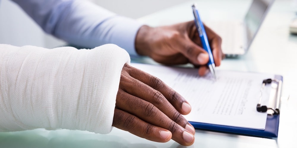 Man with Injured Hand Signing Papers